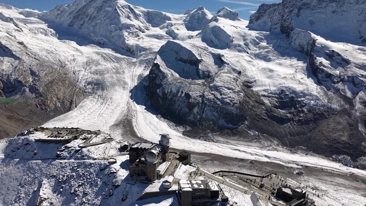 Sorvolo aereo sopra l'osservatorio del Gornergrat a Zermatt, Svizzera, con una vista che rivela il ghiacciaio del Gorner in una giornata autunnale nevosa nelle Alpi svizzere