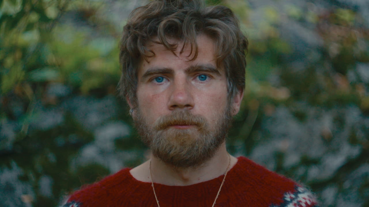 Portrait of Bearded Man in Red Sweater Standing in Forest