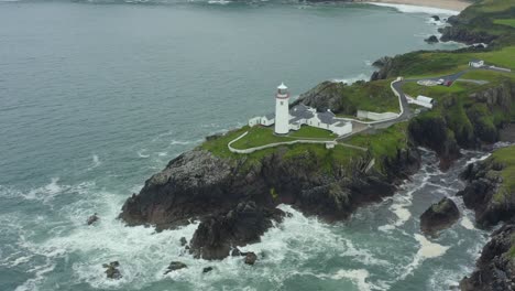 Aerial-view,-high-to-low-pan-right,-4K,-Fanad-Head-Lighthouse,-located-in-the-north-coast-of-Ireland