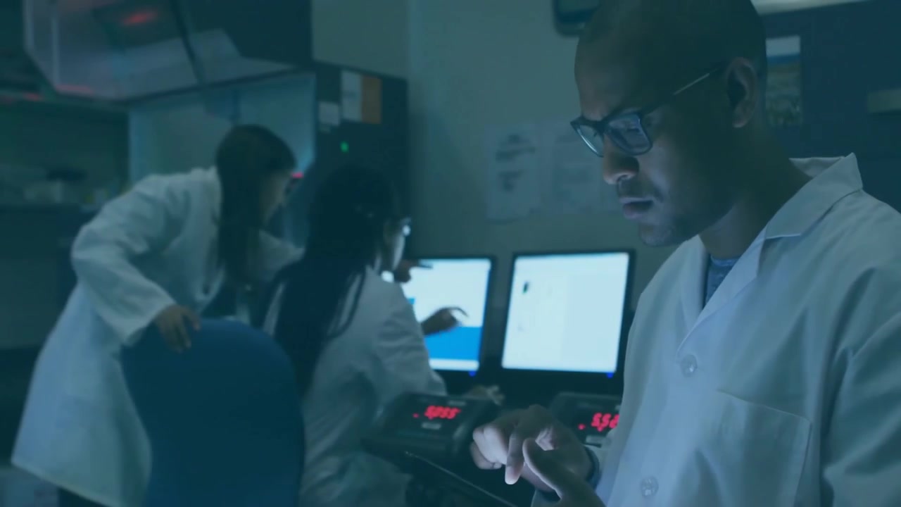 Glitch overlay flashing revealing man tapping tablet monitoring as lab team typing, pointing screen
