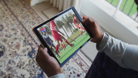 composite of man sitting at home watching hockey match on tablet