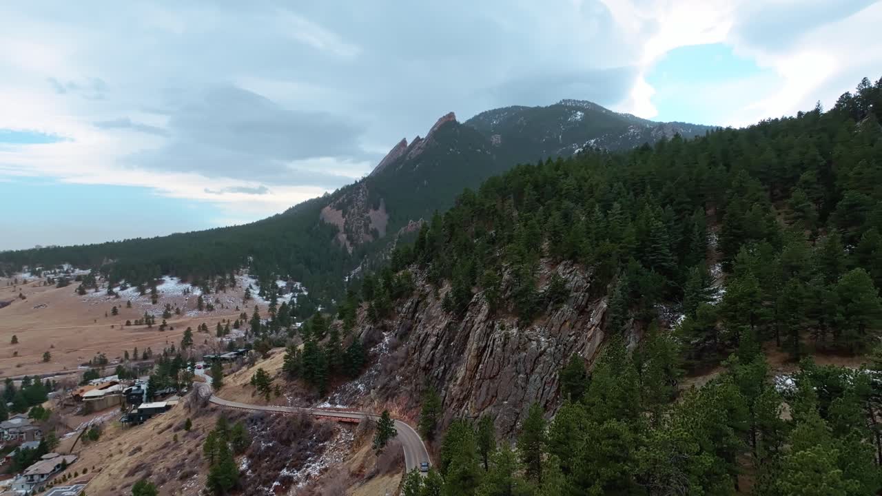 Aerial pan showcasing Boulder Flatirons’ natural beauty with rugged cliffs and scenic views