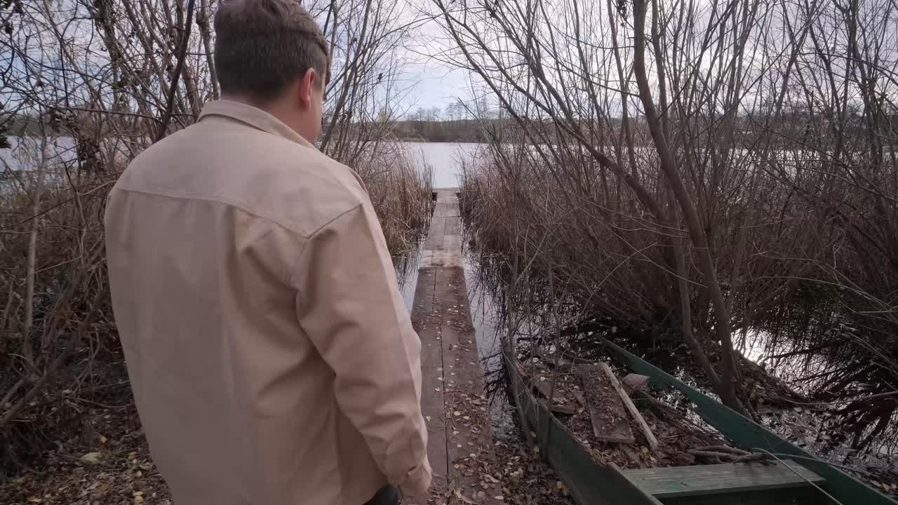 человек идет по деревянному пирсу в осенний день