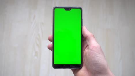 Una-Persona-Sosteniendo-Un-Teléfono-Con-Una-Pantalla-Verde