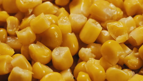 canned corn rotating on dark background. close up on opened aluminum can with corn. high quality 4k footage