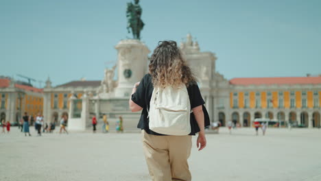 woman walking in lisbon's plaza do comercio