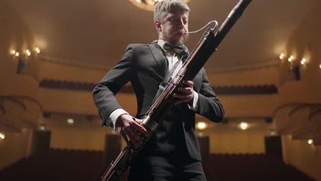 rehearsing in opera house or philharmonic hall bassoonist is playing music on scene portrait