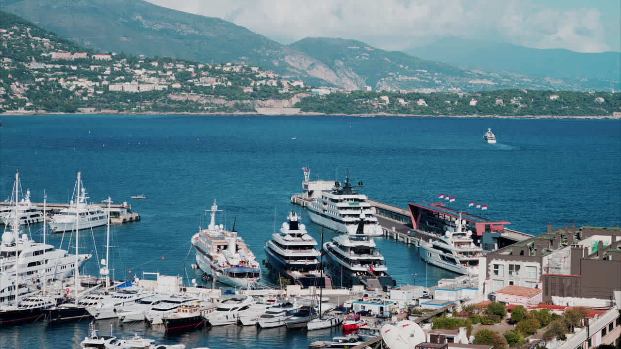 Vista aerea delle barche ormeggiate nel porto turistico di Monaco, con lo skyline della città sullo sfondo