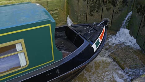 bow of narrowboat in canal lock system navigating to higher water level