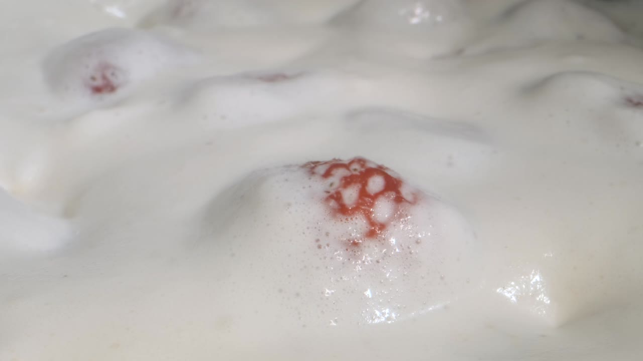 rotar las fresas maduras cubiertas con una capa gruesa de crema. rotación de la cámara 360 grados, primer plano.