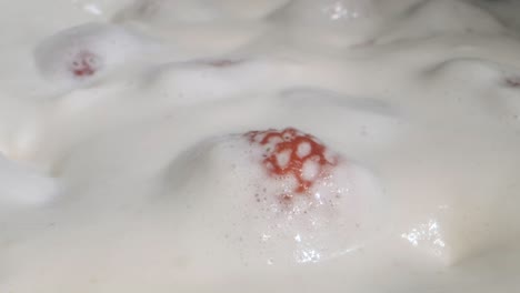 rotate of ripe strawberries covered with thick layer of cream. camera rotation 360 degrees, close-up.