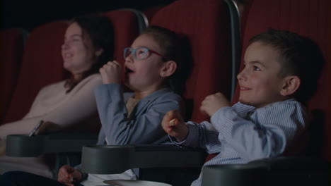 children watching movie enthusiastically in cinema. child entertainment concept