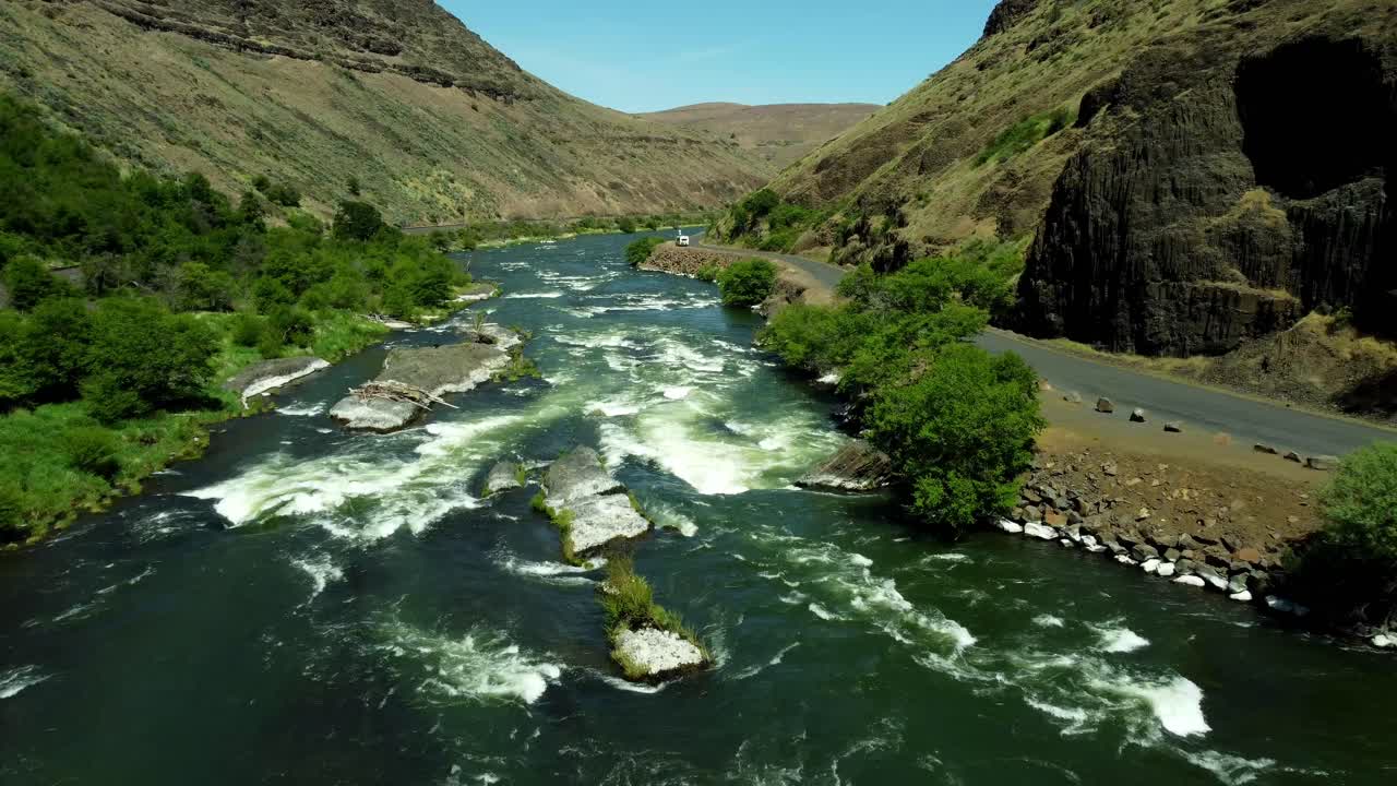 US, Oregon, Maupin, Baxter Rapids, 2025-05-08 - Drone view over the Deschutes River in Spring with a railroad line and green trees in north central Oregon