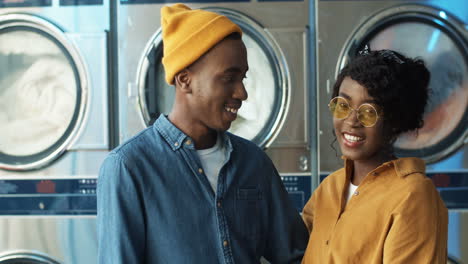 portrait shot of happy attractive couple in love hugging and smiling to camera in laundry service