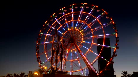 Statue of Ali and Nino on a background Ferris wheel at night on the embankment of Batumi, Georgia