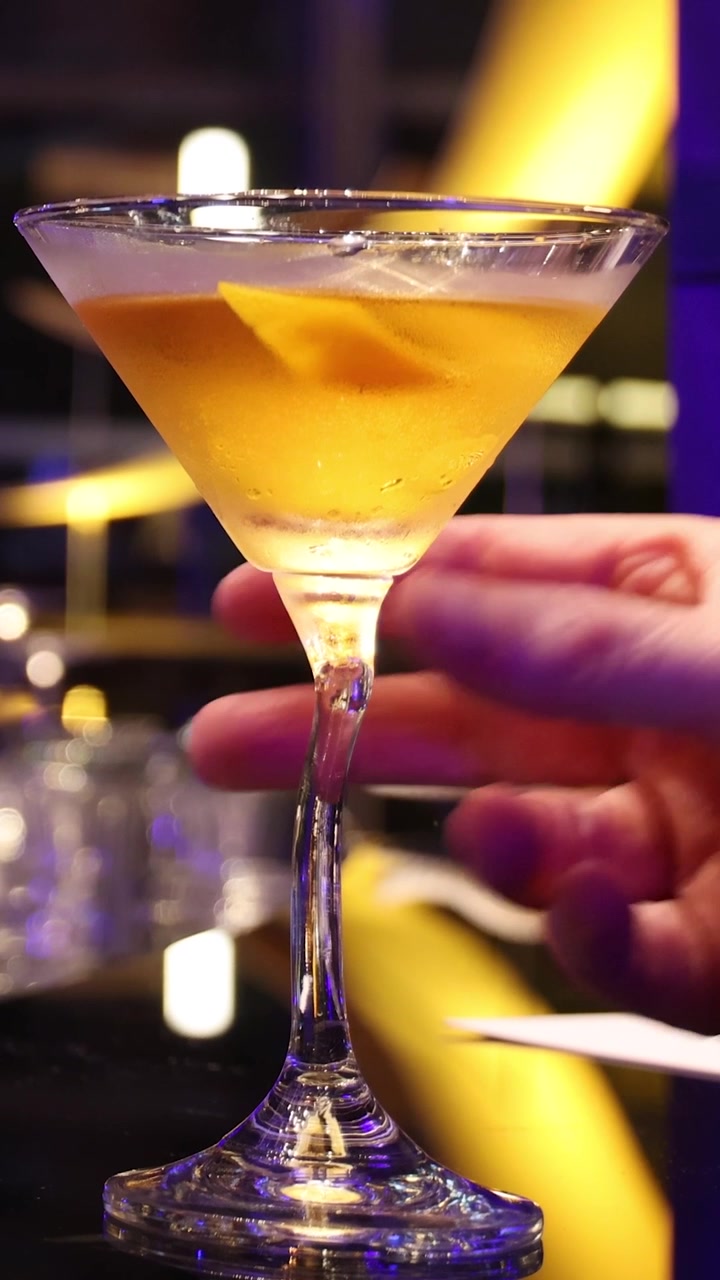 Bicchiere da Martini che si inclina e versa lentamente il liquido