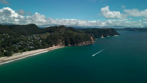 Drone-shot-of-speed-boat-flying-underneath-along-the-shore-line