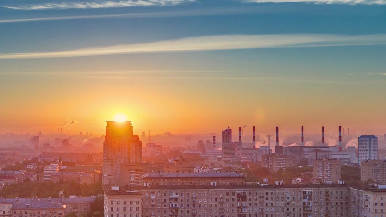 Residential buildings on Leninskiy avenue, Stalin skyscrapers, smoking pipes and panorama of city at sunrise timelapse in Moscow, Russia. Morning mist and colorfil sky. Aerial view from rooftop