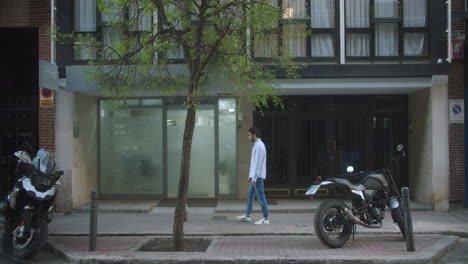 beautiful-shot-of-a-lonely-latín-young-man-walking-down-a-street-in-Madrid-in-the-evening-after-wotk-in-slow-motion