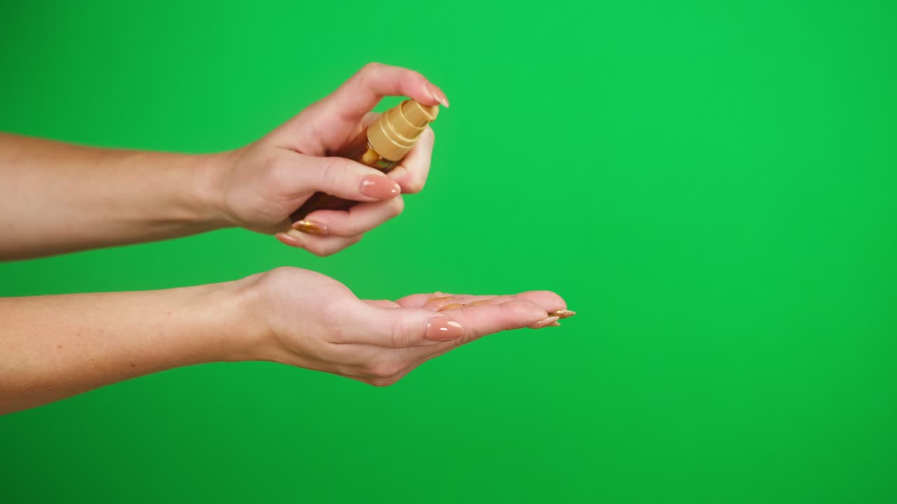 manos femeninas empujando el dispensador sobre fondo verde, usando jabón líquido. prevención de virus, protección de seguridad. brazos sosteniendo desinfectante de espuma antibacteriana de cerca