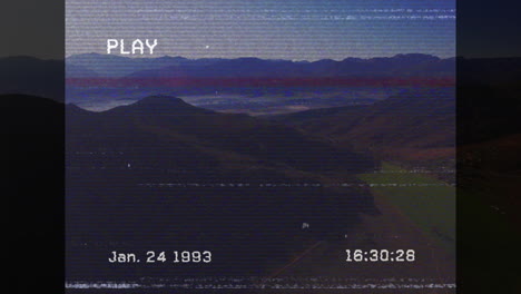 vhs-style animation overlaying date and time on mountain landscape scene