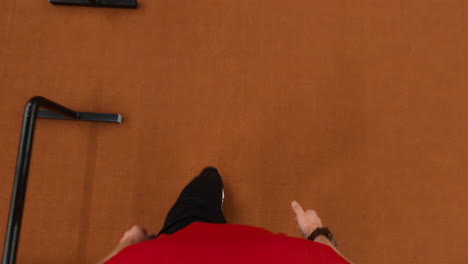 first-person view of legs walking on a brown carpet, moving past a small hurdle