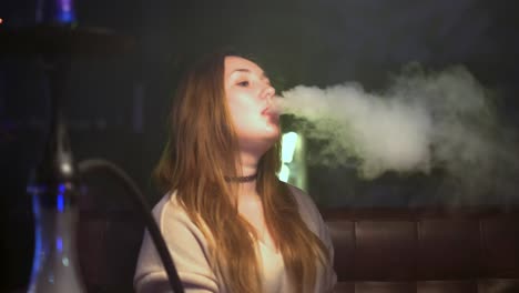 woman smoking hookah in a night club