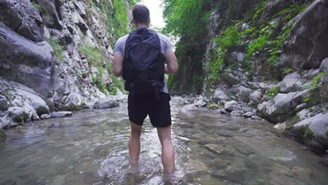joven caminando descalzo por el arroyo en el valle.