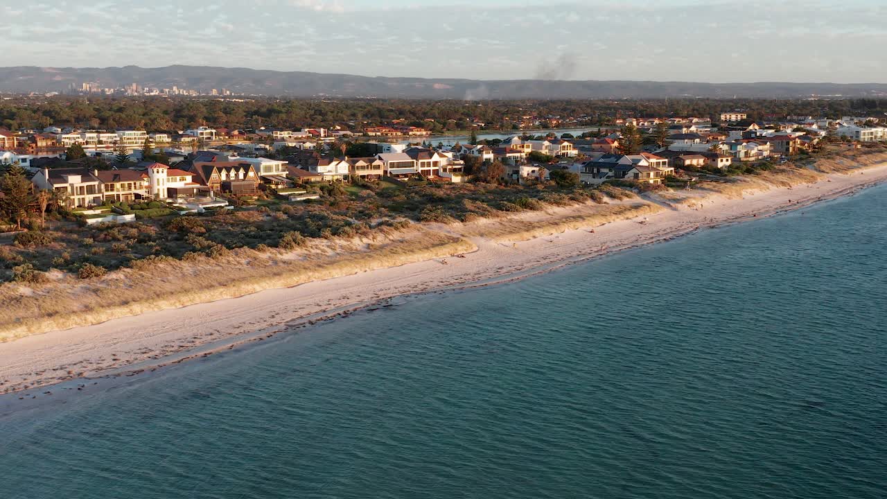 amplia imagen aérea del suburbio de tennyson beach con la ciudad de adelaide en el fondo, australia del sur
