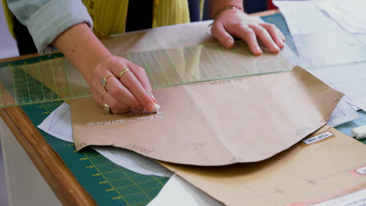 Fashion designer marking on brown paper at desk 4k