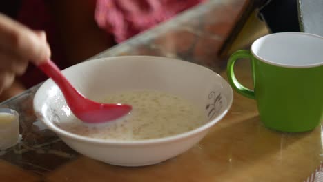 person eating a bowl of porridge