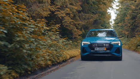 front view of a luxury car moving on the road in daylight. new electric car audi e-tron driving on the highway.