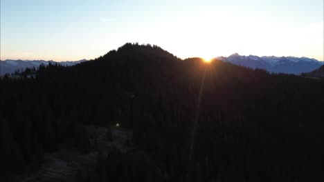 Aerial-Drone-Flight-at-Sunrise-with-Beautiful-Mountain-Landscape-surrounded-by-forest