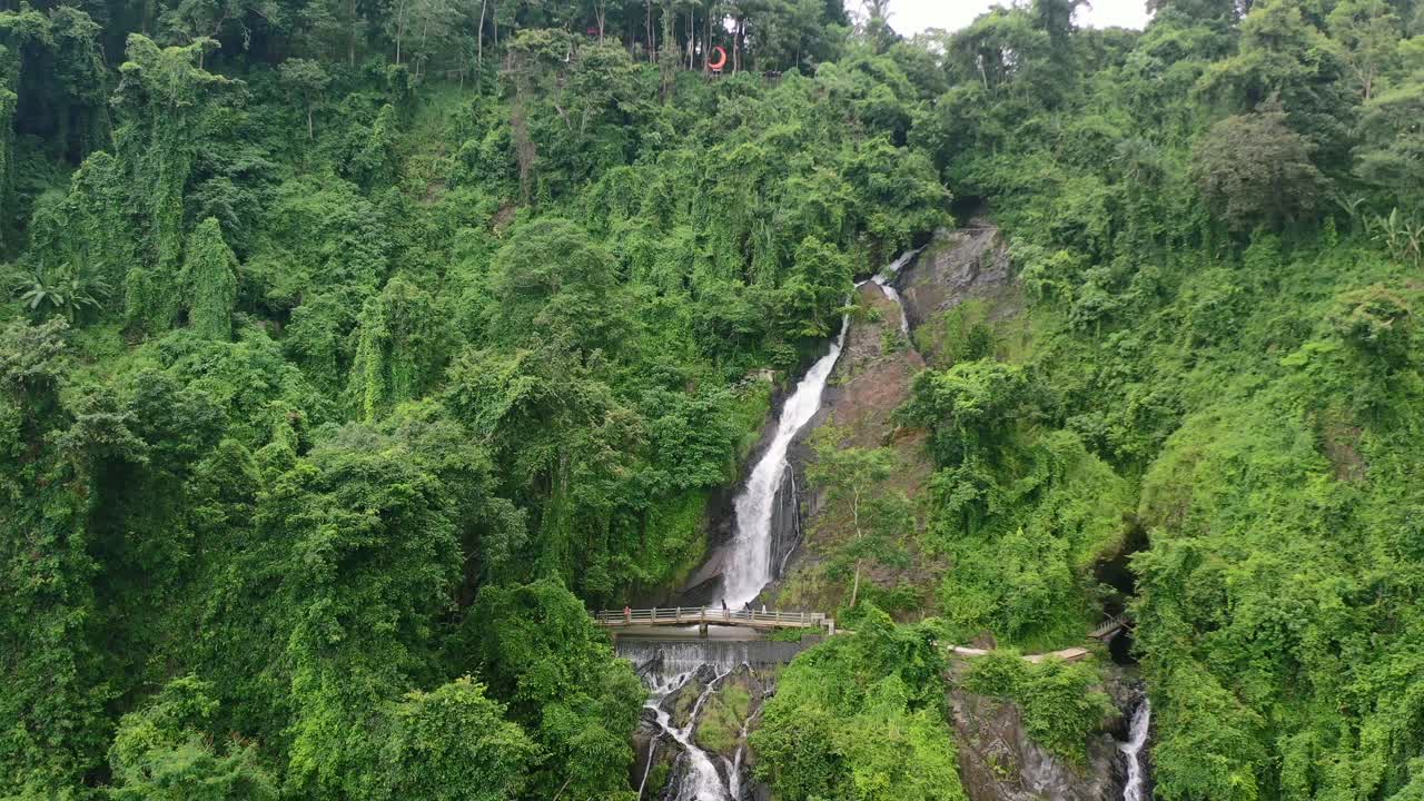 zoom aéreo fuera de la hermosa cascada en lombok con vegetación en la jungla
