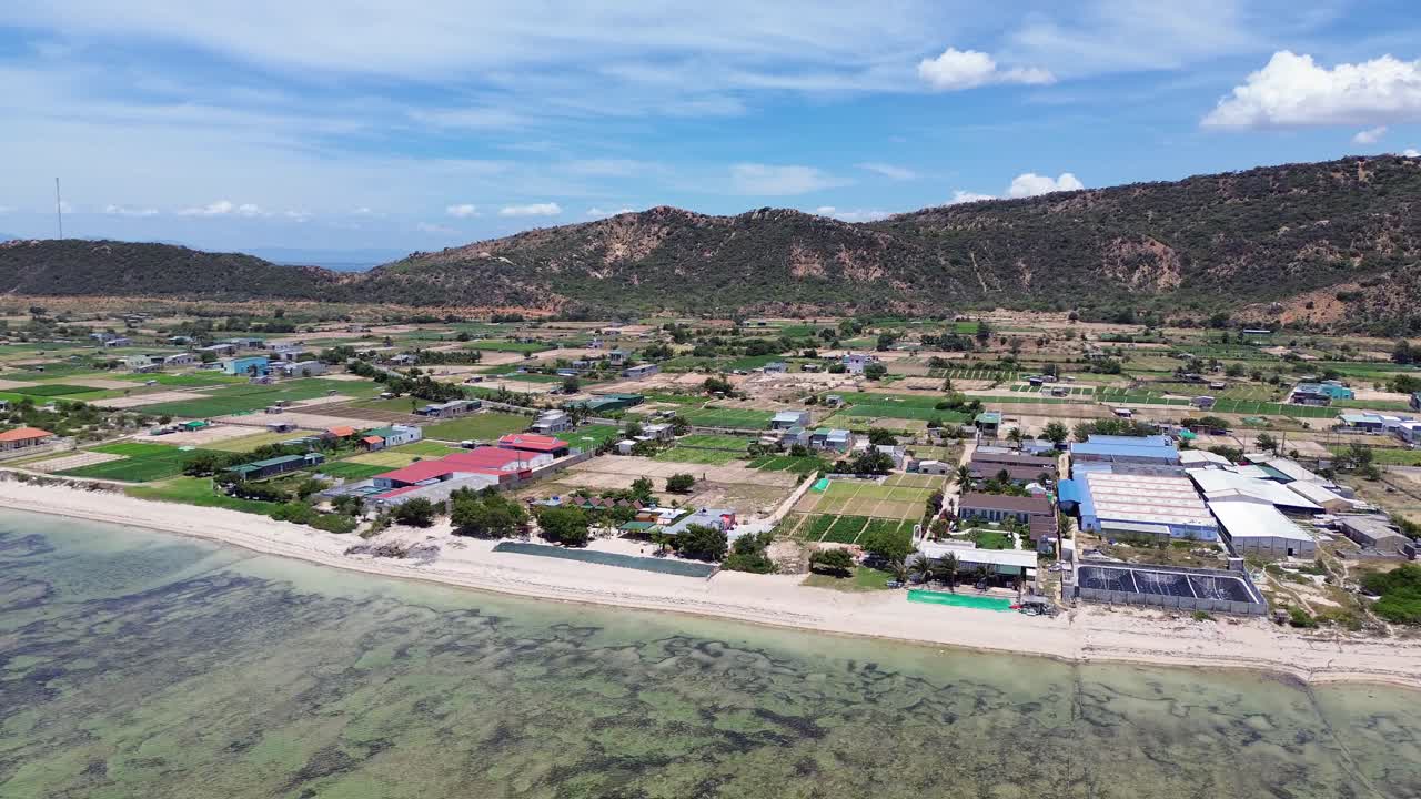 Drone aerial over My Hoa Town showing colorful rooftops and the tranquil lagoon, capturing vibrant tropical townscape in Vietnam