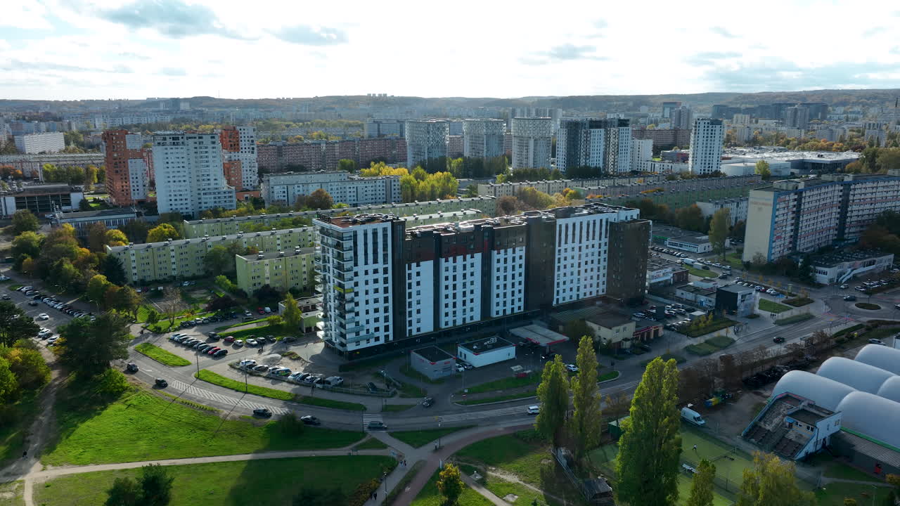 Vista aerea con drone di un grande complesso residenziale circondato da quartieri più vecchi, aree verdi e strade in un distretto urbano