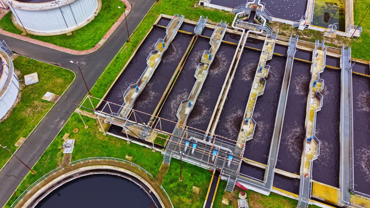 Wastewater treatment facility processes water through various stages in an urban area during daylight hours