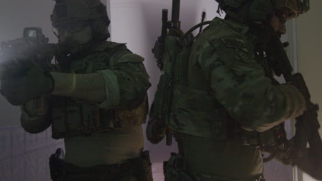 group of men in camouflage uniform and rifles playing airsoft indoor