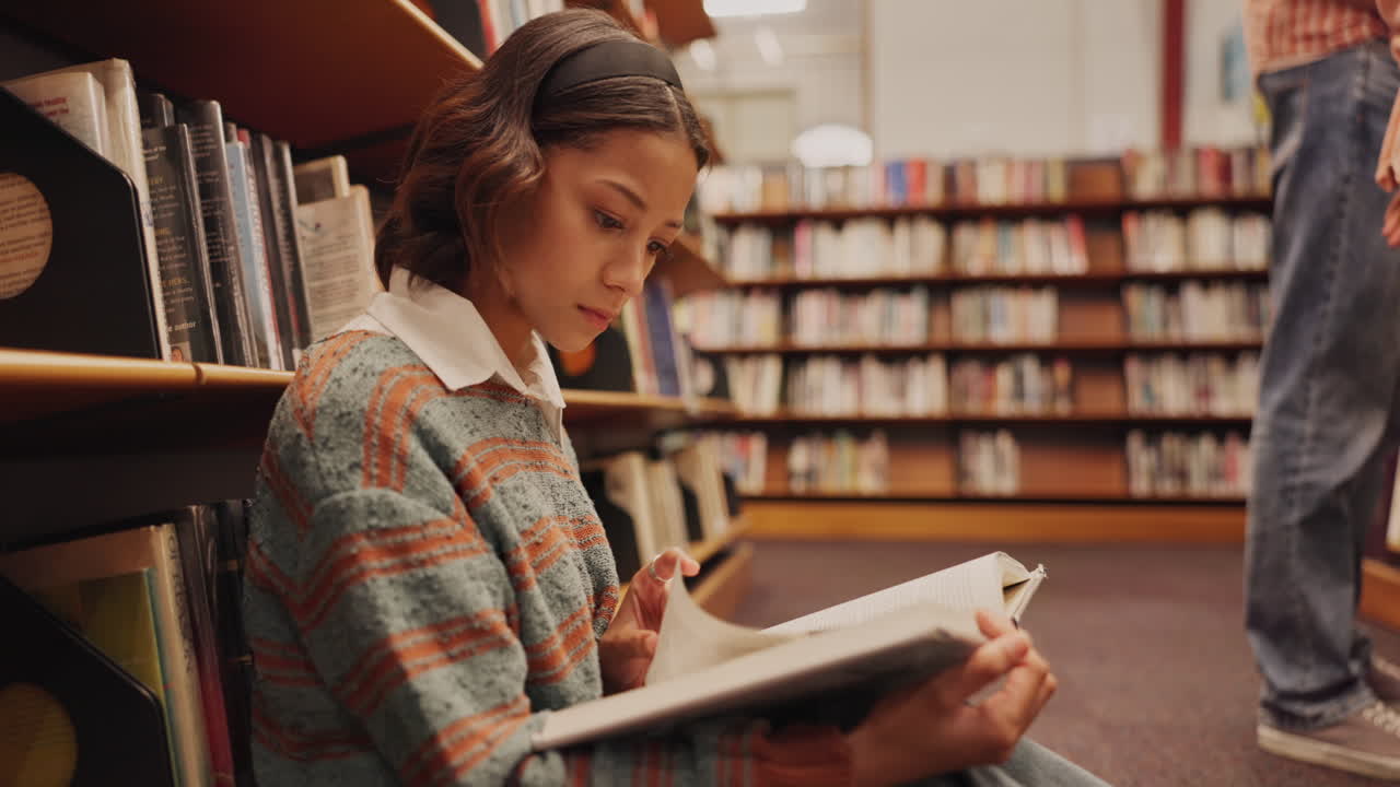 A young woman reading a book in the library