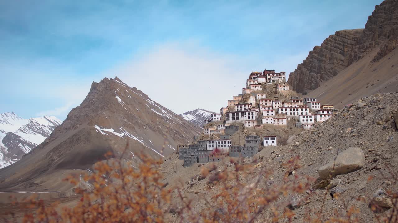 una vista pintoresca del monasterio clave en el valle spiti como se ve durante el trekking desde el pueblo clave, cerca de la frontera indochina, en el norte de la india con hierba seca y cielo despejado en el fondo