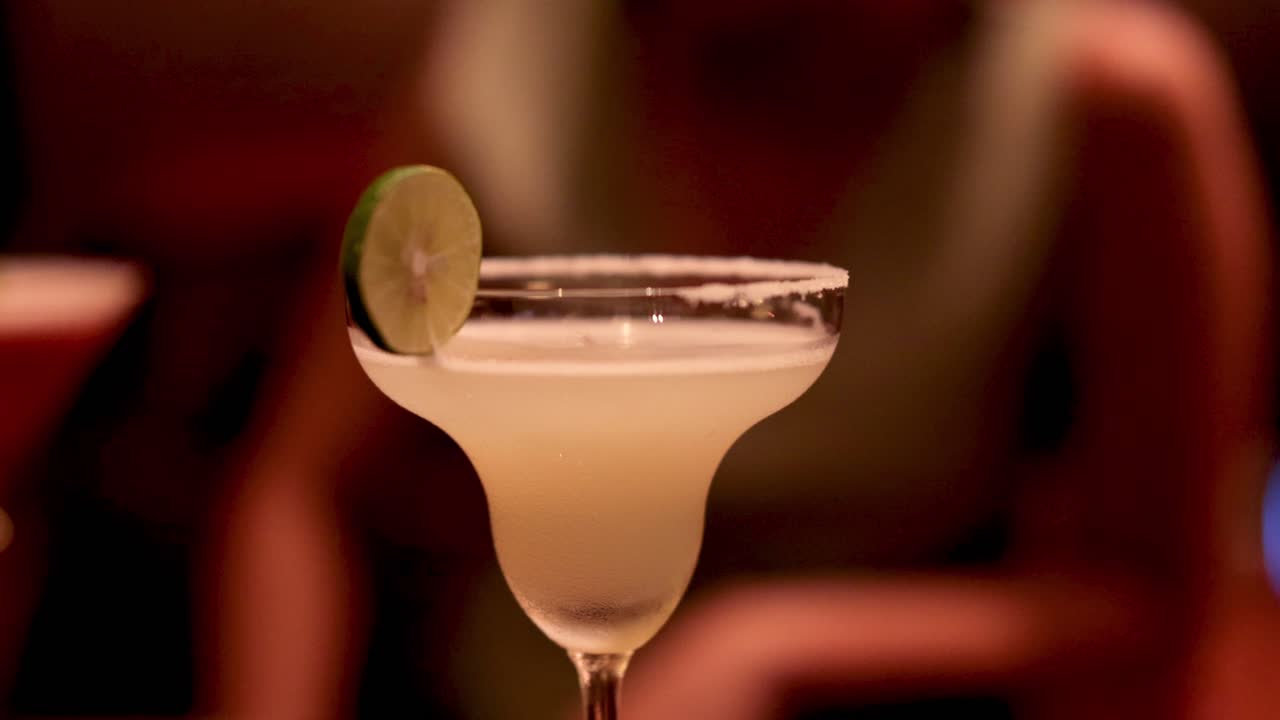 dos cócteles celebrados en una barra débilmente iluminada