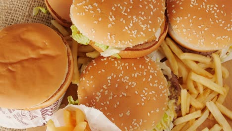 portion of unhealthy food, fast food, stack of burgers, fries rotating, top view