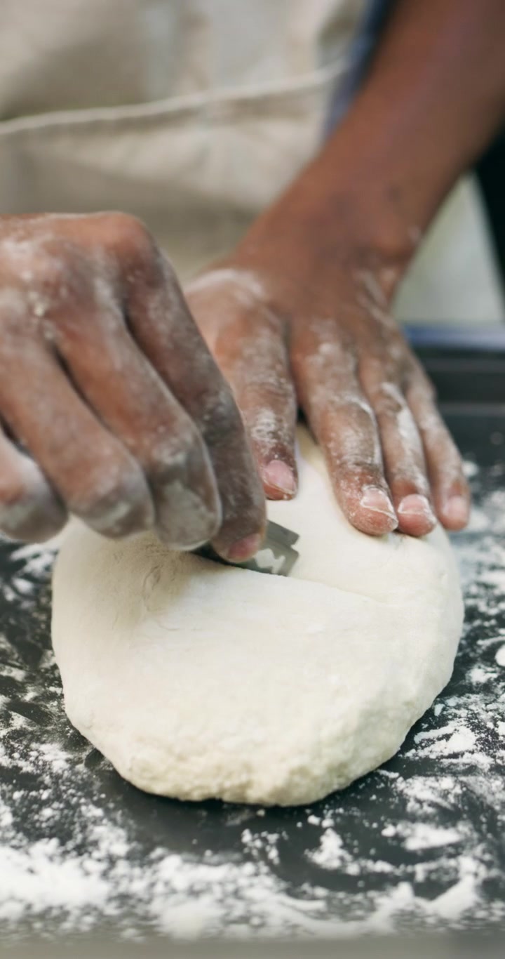Baker Scoring and Loading Sourdough Bread into Industrial Oven