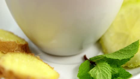 té de limón con jengibre en rodajas y hierba
