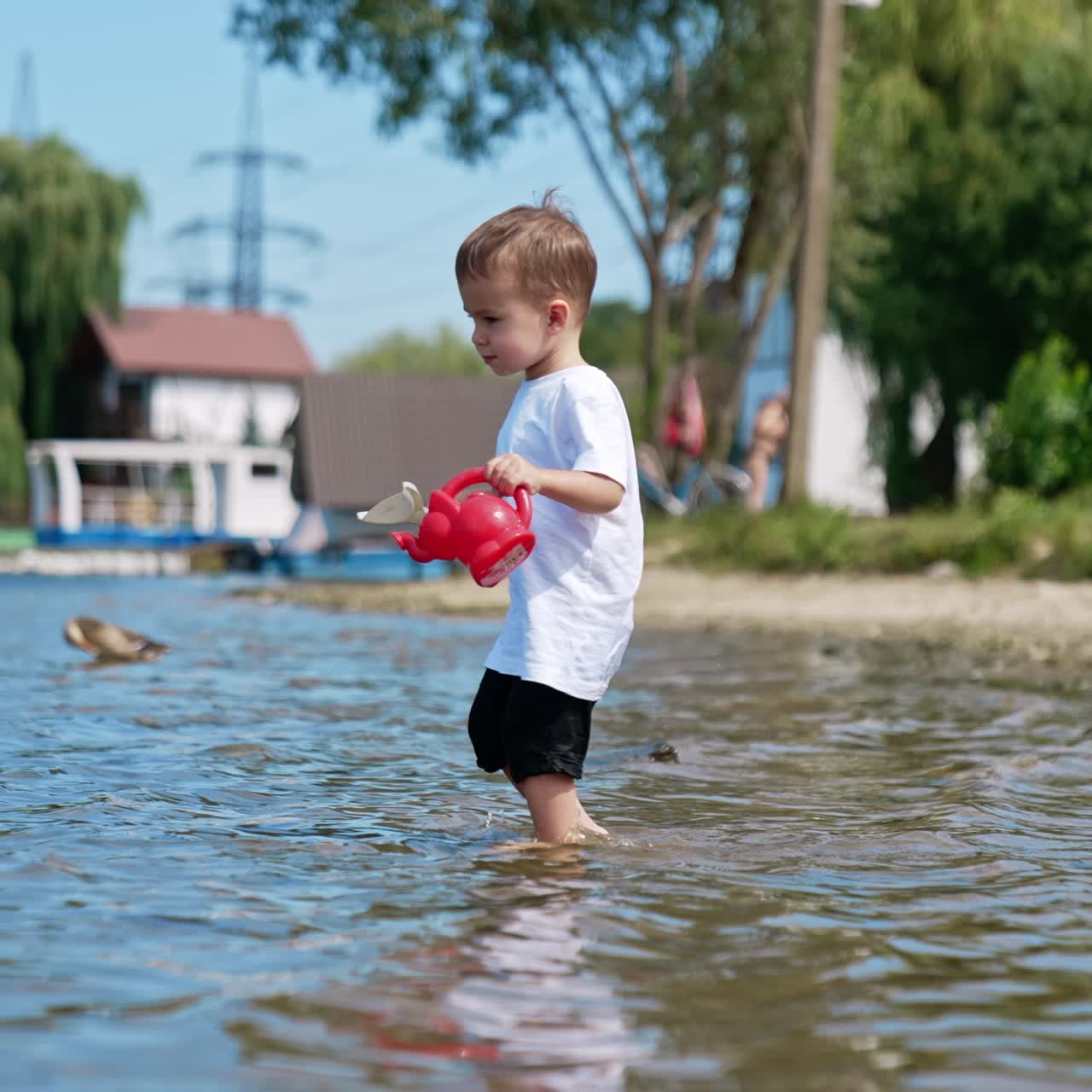 Boy playing on the beach with water. Small kid having fun at river sand beach