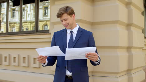 Portrait-of-successful-business-man-reading-documents-outdoors
