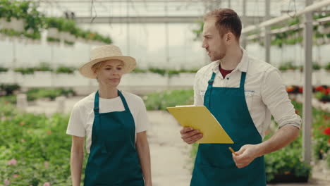 horticulturists or workers discussing plants and operations in a commercial greenhouse