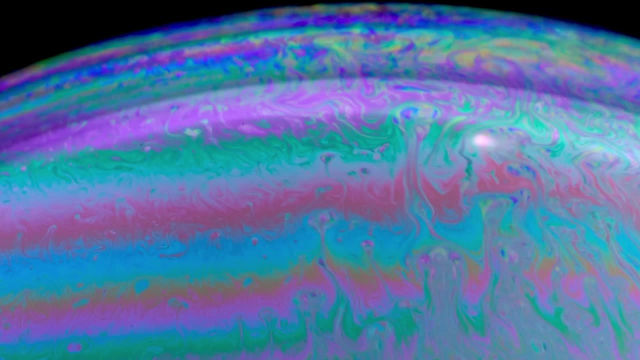 Primo piano del movimento di bolle di sapone colorate sotto una luce utilizzata per la fotografia di bolle.