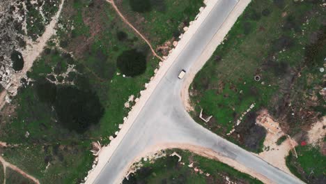 toma aérea de drones de un coche de golf conduciendo por una carretera