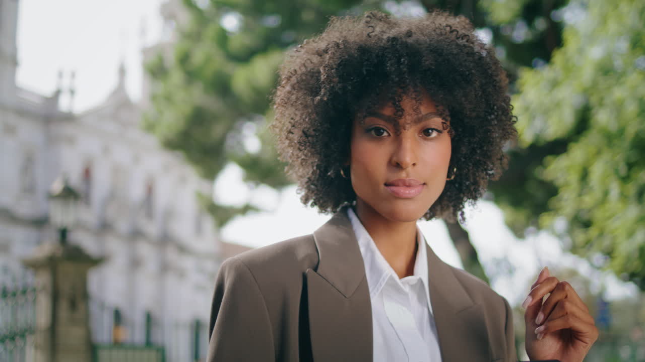 Primo piano su splendida donna in tailleur che digita sullo smartphone all'aperto. Ragazza usa il cellulare.